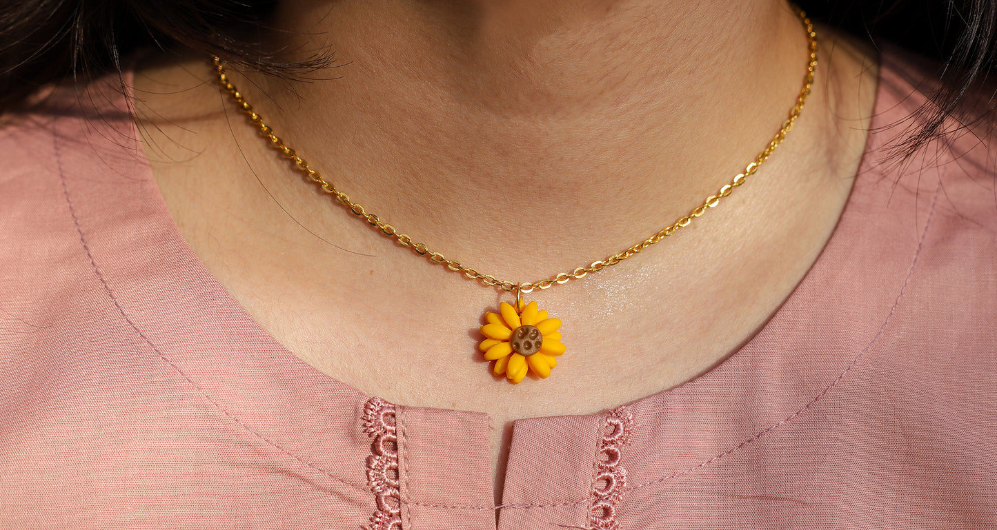 Girl wearing sunflower pendant with gold chain