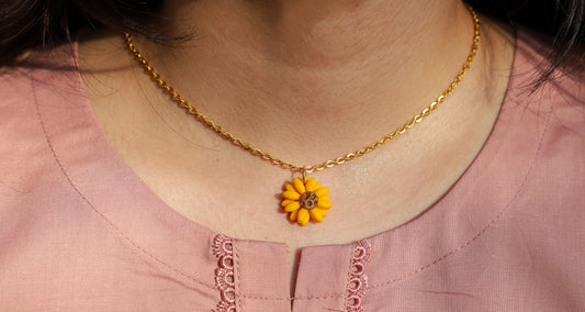 Girl wearing sunflower pendant with gold chain