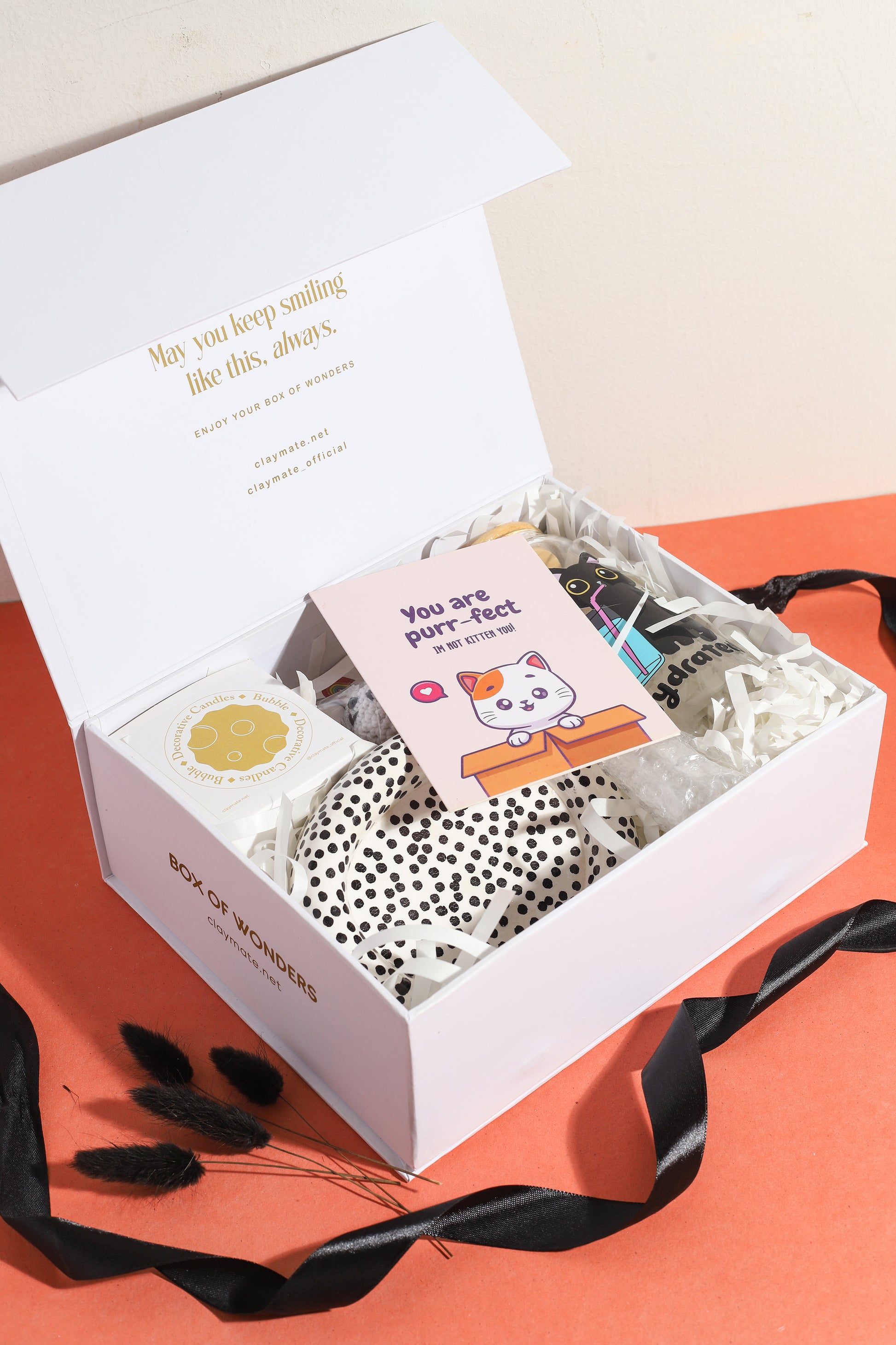 Cute cat-themed gift box featuring a ‘You are purr-fect’ greeting card, cat crochet keychain, bubble candle, black cat hydration tumbler, and polka dot ceramic dish on an orange background.