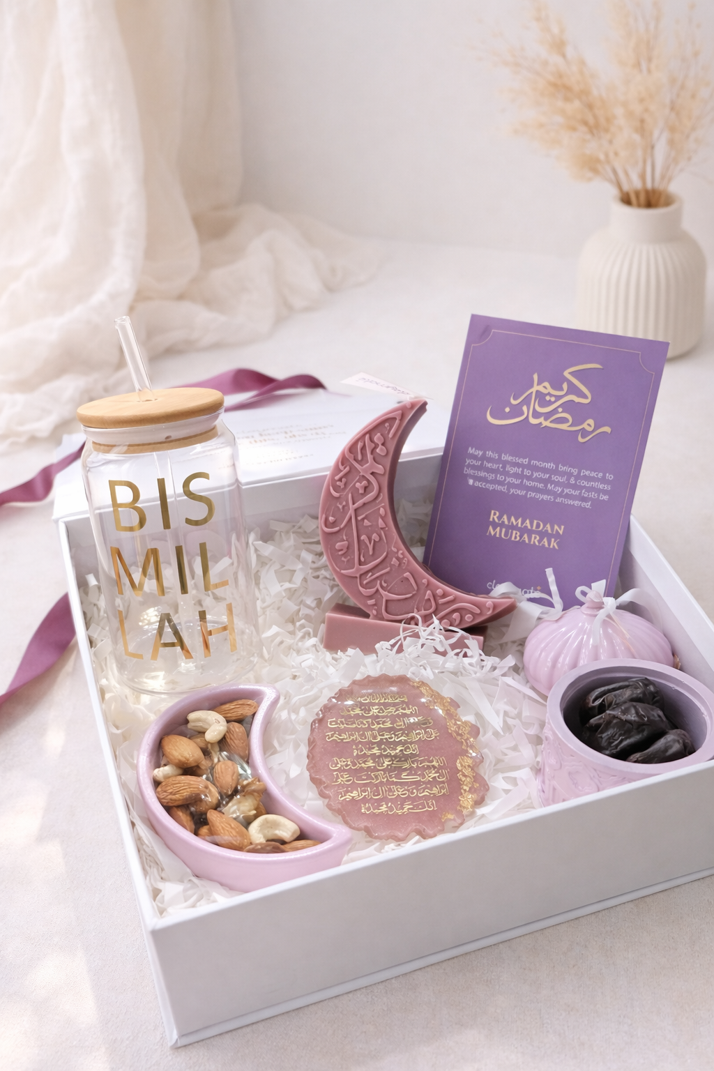 Gift box with 'Bis Mil'ah' jar, crescent moon-shaped item, and other decorative items on a white surface.