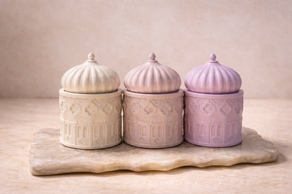 Three concrete jars with textured lids on a wooden surface