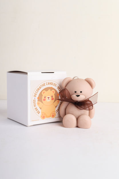 Teddy bear-shaped soy wax candle with a ribbon bow accessory.